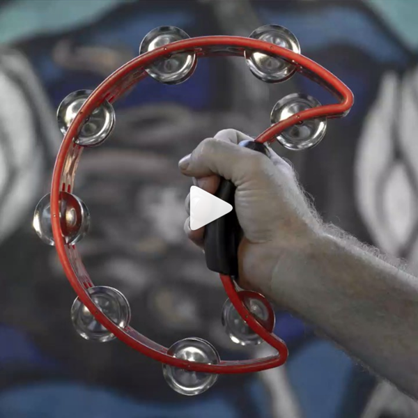 man's hand holding red crescent-shaped tambourine