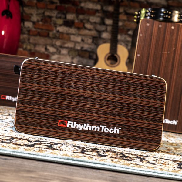 front view of Rhythm Tech Bongo Cajon in with instruments and brick wall in background